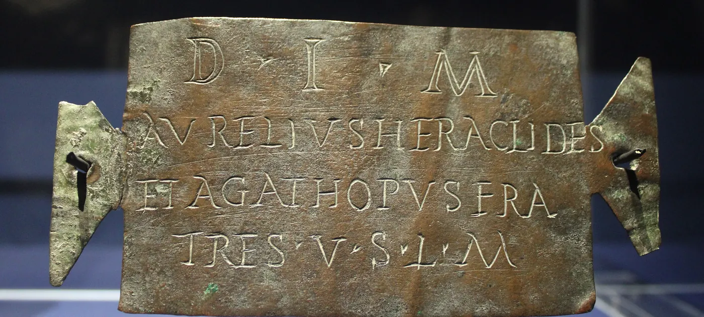 A bronze tabula ansata, a plaque with dovetail handles, inscribed in Roman capitals to Mithras by two brothers
